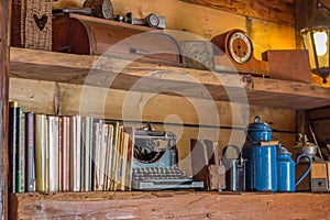 Old wooden shelf with journals and antique objects photo