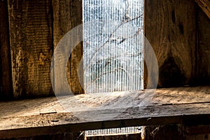 Old wooden shelf in loft in front of window