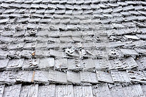 Old wooden shingles on the roof of a house as a background or texture