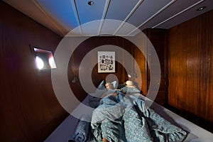 Old wooden ship cabin interor, sleeping woman in bed