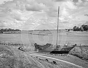 Old wooden ship in a grass field, in black and white