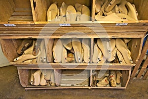 Old wooden shoe lasts in a wooden bin. photo