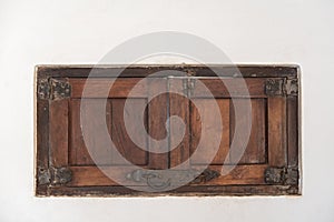 An old wooden shutter in a white wall, Mexico