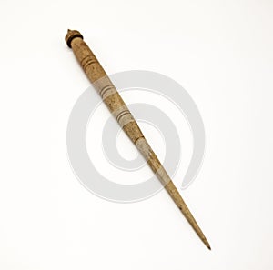 Old wooden spindle for the manufacture of woolen threads on a white background.