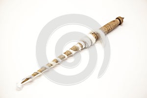 Old wooden spindle for the manufacture of woolen threads on a white background.