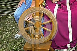 Old wooden spinning wheels and a woman in national dress.