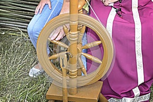 Old wooden spinning wheels and a woman in national dress.