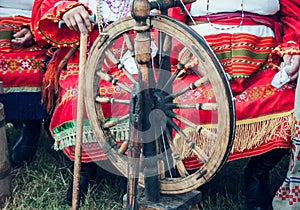Old wooden spinning wheels and a woman in national dress