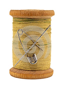 An old wooden spool of thread and a needle on a white background close-up. Threads for sewing