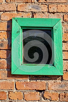 Old wooden square window on a brick wall