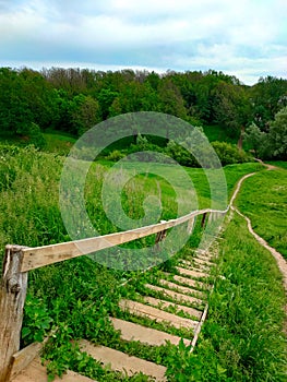 An old wooden staircase in the countryside. Way to the forest