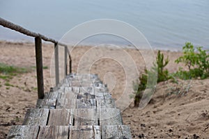 Old wooden stairs leading to the beach from the sand dunes