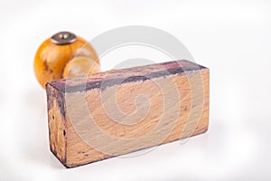 An old wooden stamp used in the office. Blank stamp on a white table