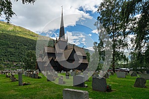 Old wooden stave chapel surrounded by cemetery, Norway