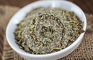 Old wooden table with dried Stevia leaves (selective focus)