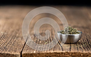 Old wooden table with dried Stevia leaves selective focus