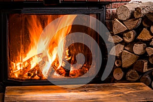 Old wooden table and fireplace with warm fire at the background
