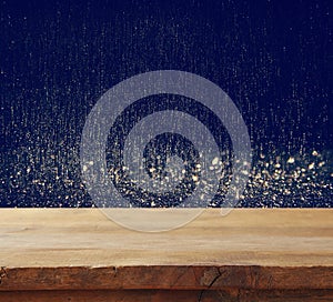 old wooden table in front of glitter lights background