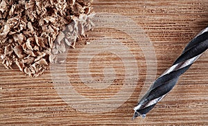 Old wooden table, sawdust and old drill bit