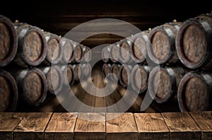 Old wooden table top and oak wine barrels at the background