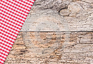 Old wooden table top view, covered with rustic red checked napkin