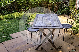 Old wooden table and two black steel chair for outdoor gardens