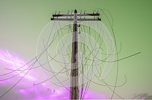 Old wooden Telegraph pole with cut electrical wires on sunset background