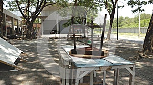 Old Wooden Three-Legged Stool Chair Lying Upside Down on Peeling Painted Tables - Messy Abandoned Backyard Garage/ Junkyard/ Garde