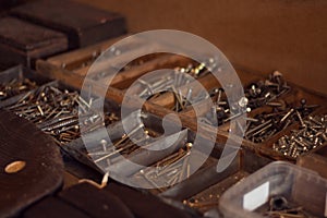 Old wooden toolbox with iron nails, screws, bolts and nuts. Storage of construction supplies in workshop. Male work box.