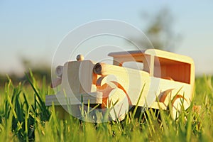 old wooden toy car in the grass outdoors in the park at sunset