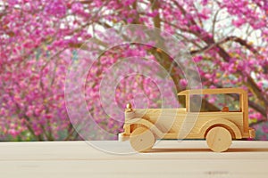 Old wooden toy car over wooden table.