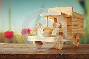 Old wooden toy car over wooden table. nostalgia and simplicity concept. vintage style image