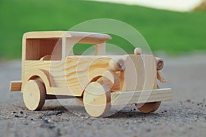 old wooden toy car on the road outdoors in the park