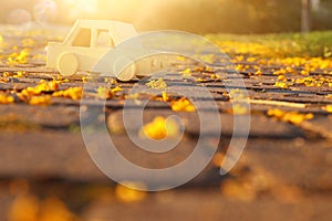 Old wooden toy car on the road outdoors in the park at sunset. nostalgia and simplicity concept.