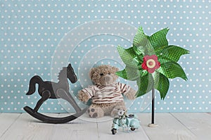 Old wooden toy horse rocking chair, teddy bear, pinwheel and blu