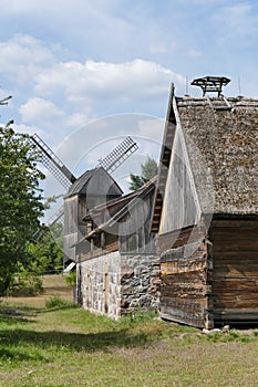 Old wooden traditional Polish windmill, barn and a house in the countryside