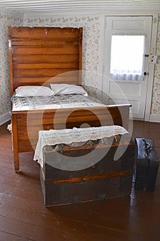 Old wooden trunk and bed in a restored bedroom