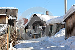 Old wooden village house with outbuildings in the winter