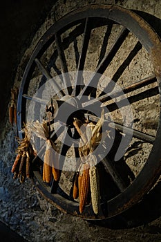 Old wooden wagon wheel with corn decoration - Old mill in the small village of Breno - Brescia - Lombardy - Italy