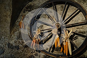 Old wooden wagon wheel with corn decoration - Old mill in the small village of Breno - Brescia - Lombardy - Italy