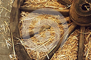 Old wooden wagon wheel lies in the manger