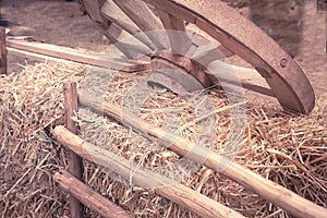 Old wooden wagon wheel lies in the manger