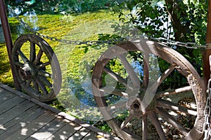 Old wooden wagon wheels beside lake