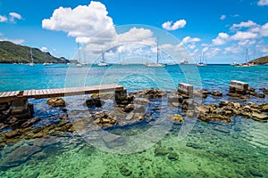 Old wooden walkway over the water to the beach in Bequia.