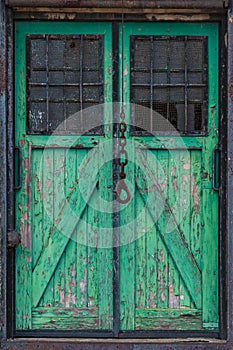 Old wooden warehouse door with a crane hook in front