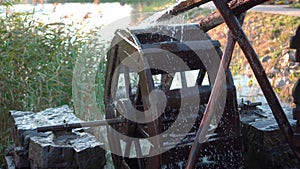 Old wooden water mill with rotating wheel