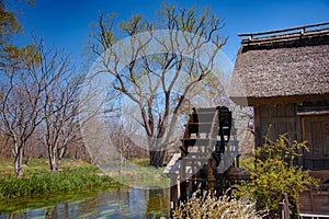 Old wooden water mill on the Sai River, rural setting and clear blue sky