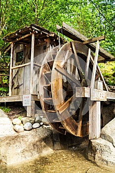 Old wooden water mill with the wheel turning