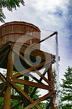 An old wooden water tank from which water comes out