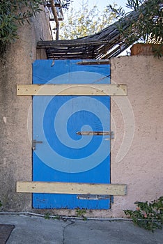 Old wooden weathered door painted blue closed with wood panels
